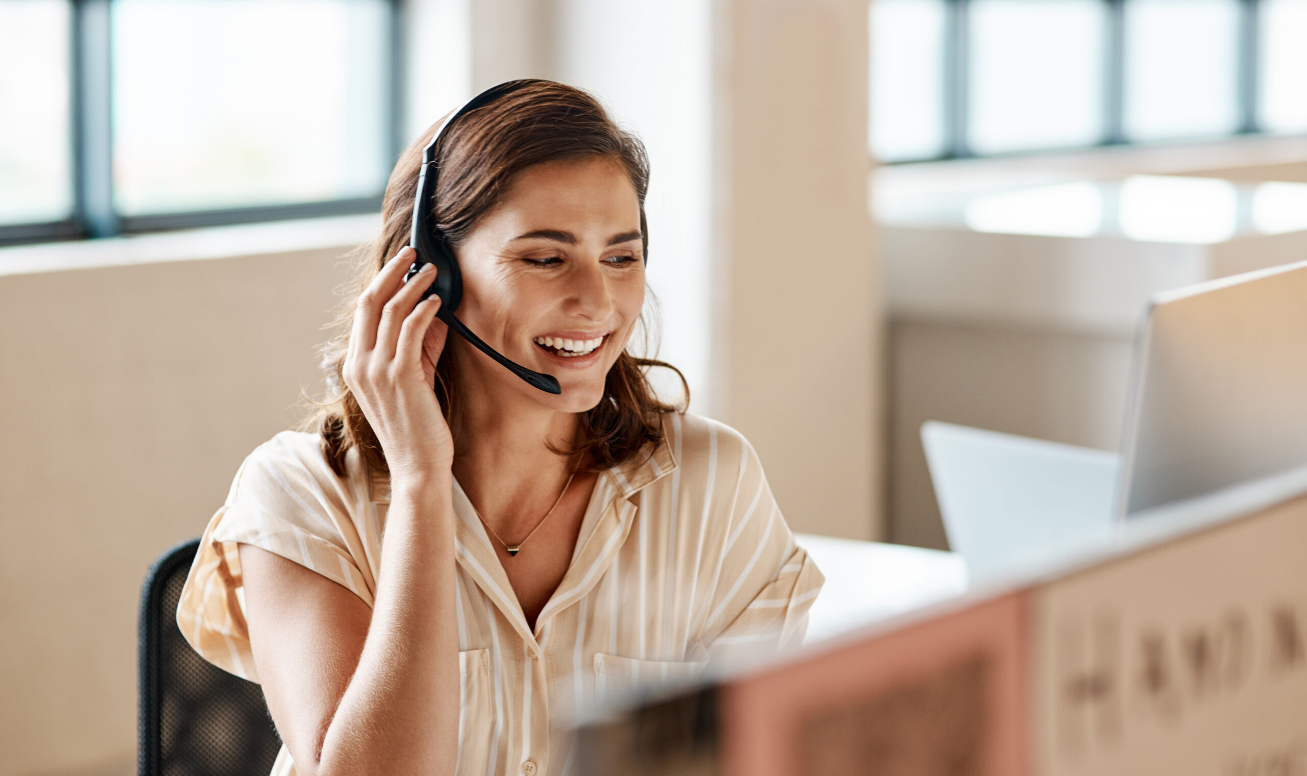 Shot of a young businesswoman wearing a headset while working on a computer in an office